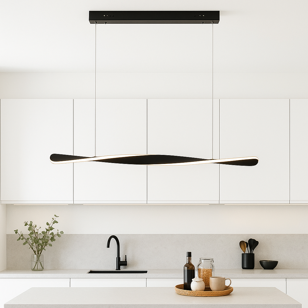 Modern black twist LED pendant light in a white kitchen with black accents and styled countertop accessories.